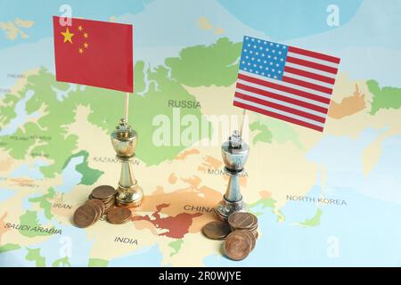 Chess pieces with American and Chinese flags and coins on map. Trade war Stock Photo