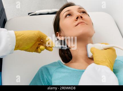 Fine needle aspiration biopsy of thyroid gland for woman patient guided of doctor with ultrasound machine. Thyroid biopsy Stock Photo