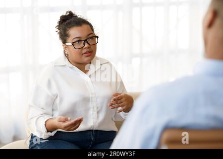 Anxious woman plus size sharing thoughts with psychologist Stock Photo