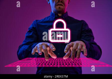 Businessman, programmer typing on virtual, digital keyboard with padlock symbol, developing security system for private data. Cybersecurity. Stock Photo