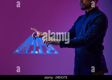 Businessman, programmer typing on virtual, digital, wireless keyboard. Innovation, cyberspace, holographic image of computer tool Stock Photo