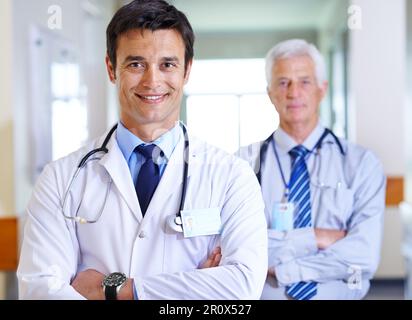 Proud of his private practice. Portrait of two smiling doctors standing in a corridor. Stock Photo