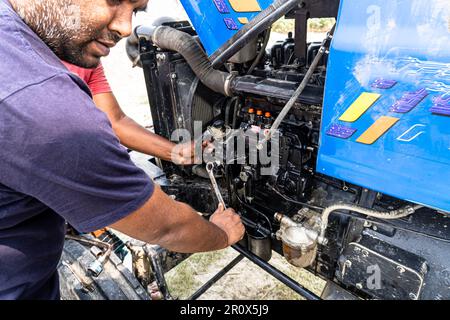 Close-up of a human hand holding the industrial tools for maintenance or machine service using the outdoor side for use in agriculture. Stock Photo