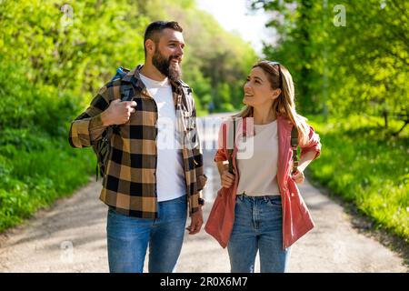 Happy couple hiking in nature on sunny day. Couple enjoying their vacation. Stock Photo