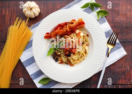 Spaghetti with bacon and dried chili at table top  view - Spaghetti Aglio E Olio Stock Photo