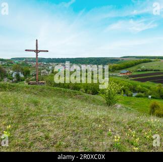 Wooden сhristian religious cross near Rukomysh Cave temple and spring country fields and village, Buchach District, Ternopil Region, Ukraine. Stock Photo