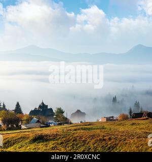 Morning fog on the slopes of the Carpathian Mountains (Yablunytsia village, Ivano-Frankivsk oblast, Ukraine). Autumn rural landscape. Stock Photo