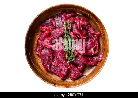 Raw uncooked beef meat sliced in strips with fresh herbs for beef stroganoff. Isolated on white background Stock Photo