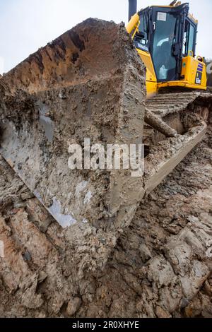 Ust-Luga, Leningrad oblast, Russia - November 16, 2021: Dirty dozer closeup photo. Groundworks in rain Stock Photo