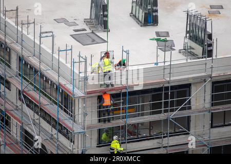 Glazier installing windows on a commercial building. Stock Photo