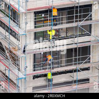 Glazier installing windows on a commercial building. Stock Photo