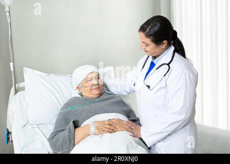 Indian doctor visit senior patient with nasal cannula lying in hospital bed, Medical person give support and care at clinic, health care concept. Stock Photo
