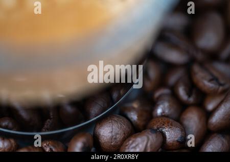 Glass cup of cofee on the coffee beans detail. Selective focus. Abstract illustration. Stock Photo