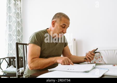 middle-aged man writes notes in notebook Stock Photo