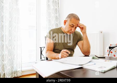middle-aged man writes notes in notebook Stock Photo