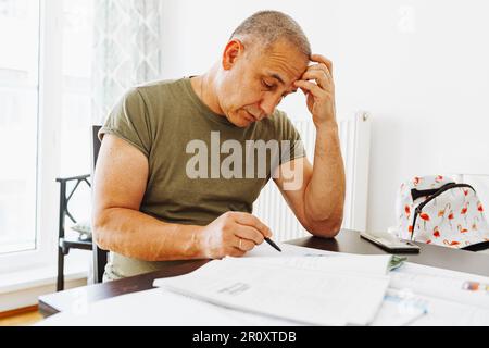 middle-aged man writes notes in notebook Stock Photo