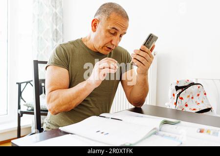middle-aged man writes notes in notebook Stock Photo