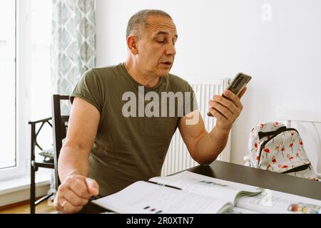 middle-aged man writes notes in notebook Stock Photo