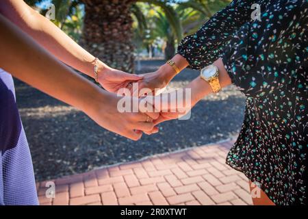 Two women are holding hands, concept of unity and support between females. Stock Photo