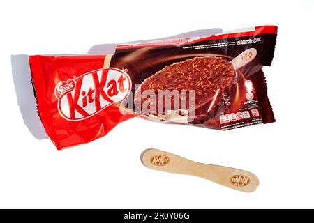 Ho Chi Minh City, Vietnam - May 10, 2023: KitKat ice cream torn wrapper isolated on white. Popular dessert Kit Kat red packaging and a stick with bran Stock Photo
