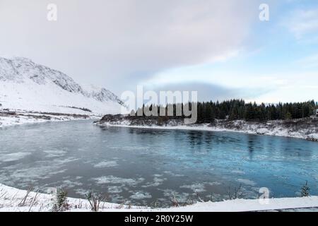 Winter view of the Sogid river, part of the Sogid nature reserve near Selfoss in Iceland bending through a snowy mountainous landscape Stock Photo