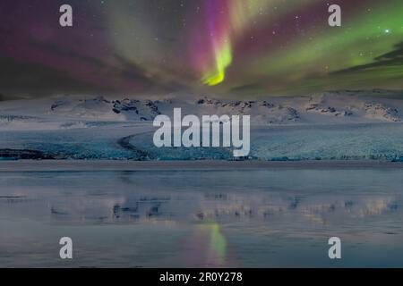 Close up of Jokulsarlon glacier in the lagoon during winter with Aurora Borealis or Northern Lights and thousands of stars Stock Photo