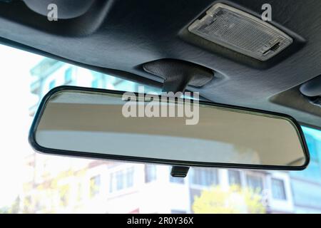 Close up old classic style rear view mirror inside of car. Mirror in the car looking back. Selective focus of mirror. Stock Photo