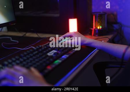 Female cyber hacker gamer using keyboard and mouse to playing games or hacking programming system. Stock Photo