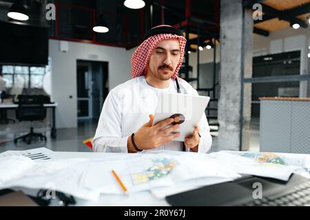 Arab muslim businessman using digital tablet in modern office Stock Photo