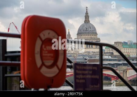 LONDON - April 21, 2023: St Paul's Cathedral, one of the most iconic landmarks in London, captured with an out of focus red life ring in the foregroun Stock Photo