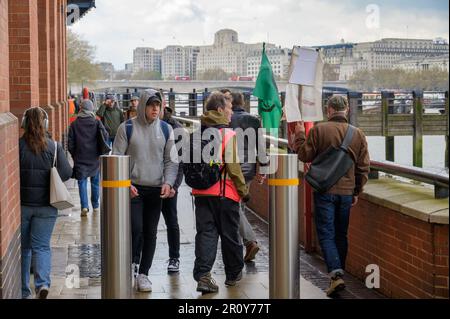 LONDON - April 21, 2023: Protestors wave flags and banners as they call for sustainable living and renewable energy on Southbank. Stock Photo