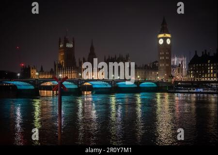 LONDON - April 21, 2023: View the iconic Palace of Westminster and Westminster Bridge illuminated at night, reflecting on the River Thames. Stock Photo