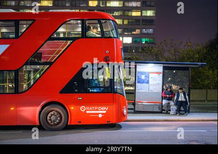 LONDON - April 21, 2023: A red London double-decker bus waits at a stop outside St Thomas's Hospital, an iconic sight in the heart of the city. Stock Photo