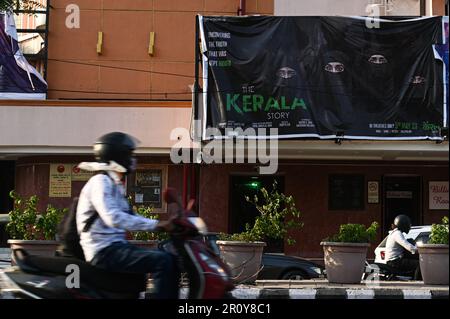 New Delhi, Delhi, India. 10th May, 2023. A man rides his two-wheeler past a poster of a Hindi film titled ''The Kerela Story'', outside a cinema in New Delhi, India on May 10, 2023. (Credit Image: © Kabir Jhangiani/ZUMA Press Wire) EDITORIAL USAGE ONLY! Not for Commercial USAGE! Stock Photo