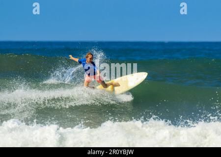Shortboard surfer does a cutback turn on a wave at this fast-growing surf beach & yoga destination. Playa Guiones, Nosara, Guanacaste, Costa Rica Stock Photo