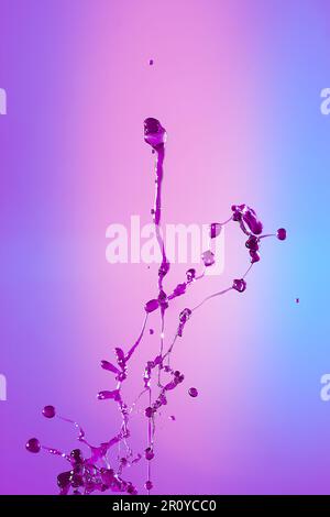 Abstract background of a splash of colored water, collision of colored drops falling towards each other. Close up. concept art Stock Photo