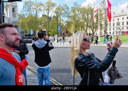 Tourists taking photographs in Parliament Square Westminster Central London on a sunny spring day, England Great Britain UK Stock Photo