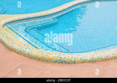 Resort design pool resort swimming pool mosaic tile pool border tile blue water hotel background water surface. Small square tile. Abstract hotel Stock Photo