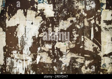 Scraps of worn out torn papers in old bulletin board, grunge background Stock Photo