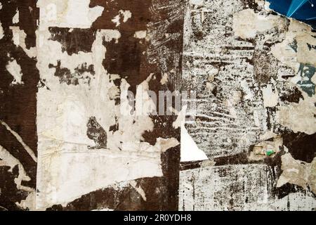 Scraps of worn out torn papers in old bulletin board, grunge background Stock Photo