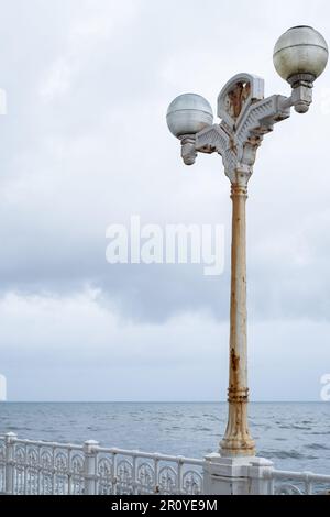 Rusty ornate lamp post with the sea behind, Donostia San Sebastian, Basque Country Stock Photo