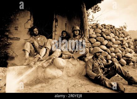 Marines of the 1st Marine Division relax by a Korean hut after destroying an enemy sniper housed there.  September 24, 1951.  Photo by Sgt. Frank  W. Sewell. (Marine Corps) Stock Photo