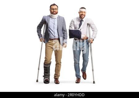 Two young injured men standing with crutches isolated on white background Stock Photo