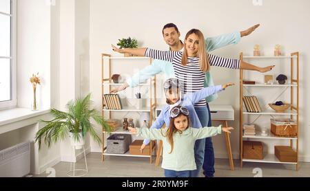 Happy little children together with their parents playing and flying planes at home Stock Photo