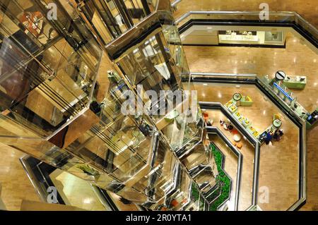 A group of people riding on escalators in an urban environment, ascending to the next level of the city Stock Photo