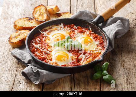 Eggs in Purgatory healthy Italian Shakshuka closeup on the skillet on the wooden table. Horizontal Stock Photo