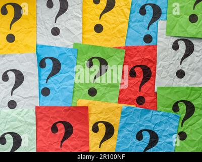Crumpled colorful paper notes with question marks. Close up. Stock Photo