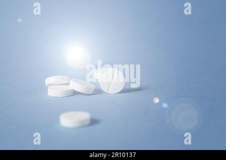 Sun glare on medical pills, sunbeam shining on pills. Many medical pills of different colors and shapes scattered, close-up. Copy space Stock Photo
