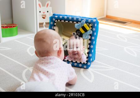 Baby looking in the mirror during tummy time Stock Photo