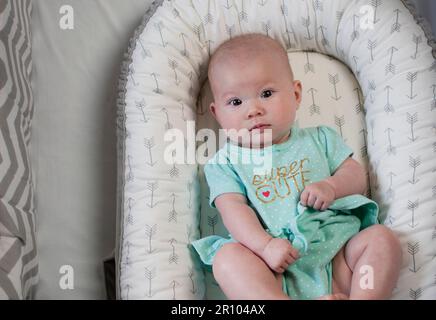 4 months old Caucasian cute baby girl in a crib. Infant girl. Newborn baby. Stock Photo